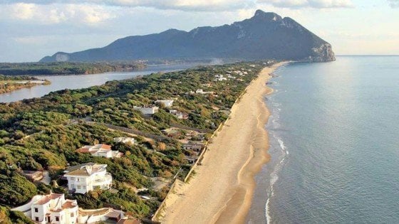 L’uomo col cappotto cammello e la cartolina macchiata delle dune di Sabaudia